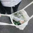 manos sostienen bolsa de tela con botellas de vidrio para reciclaje; negocios sostenibles