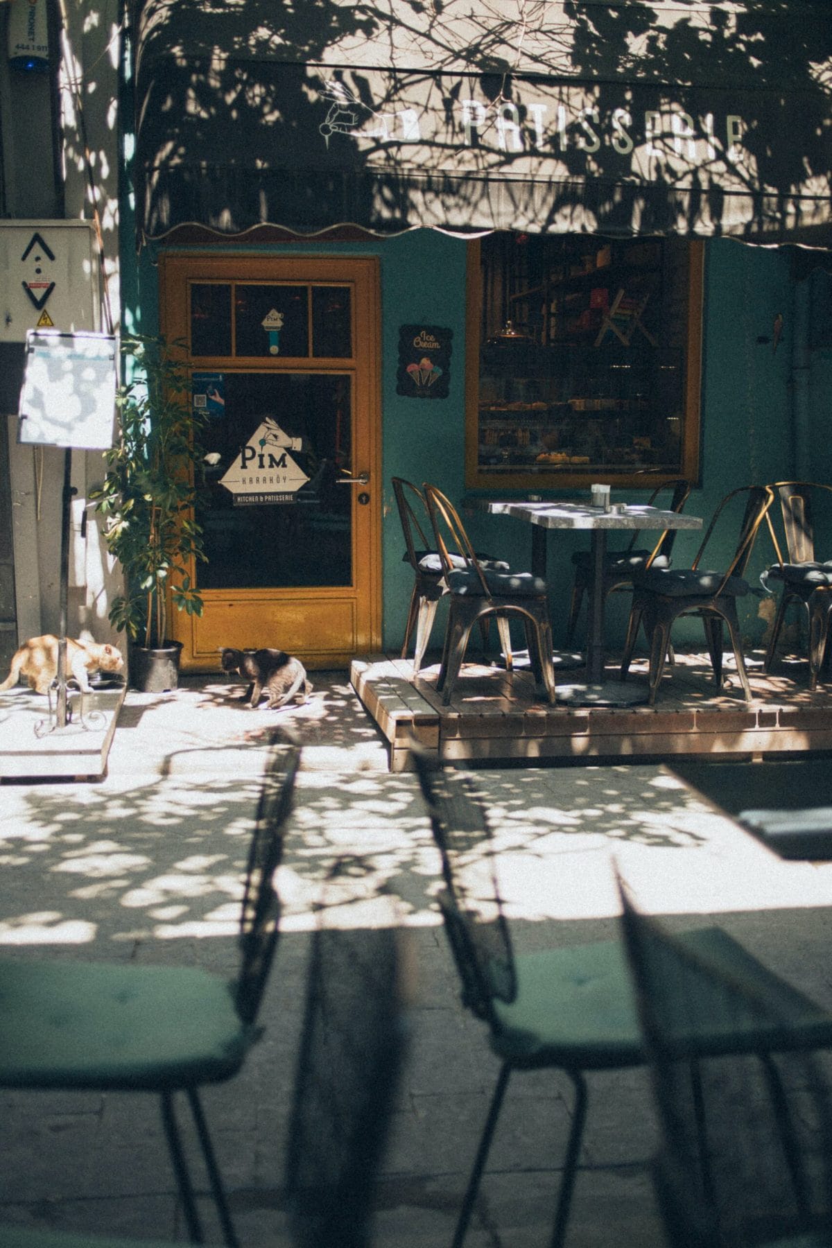 Exterior de café, color azul, mesas en exterior y día soleado