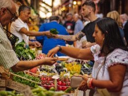 personas comprando frutas y verduras en un mercado al aire libre