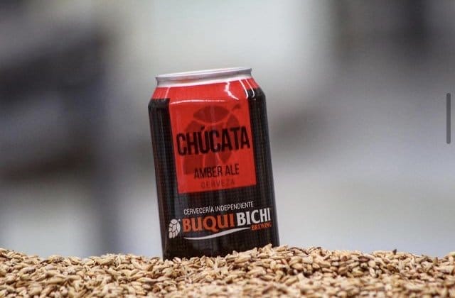 Lata de cerveza color negro con rojo, la parte de abajo Buqui con letras color naranja y Bichi con letras color blanco