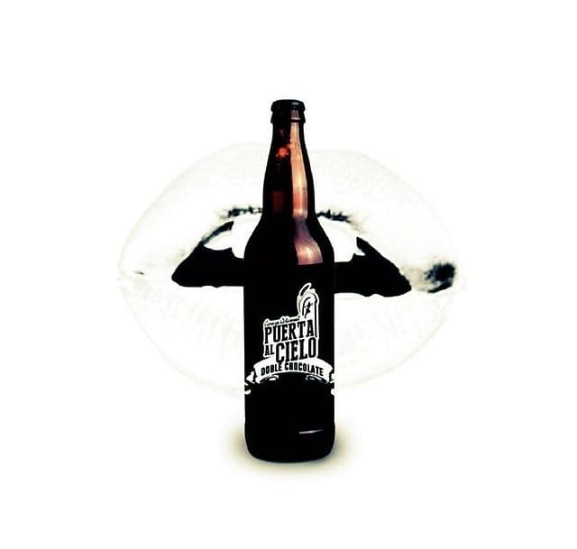 Botella de vidrio color ambar con etiqueta color negra y con letras color blancas.