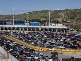 Linea de la frontera de Tijuana. En medio hay una línea color amarillo fuerte y por los dos lados se encuentran diversidad de carros