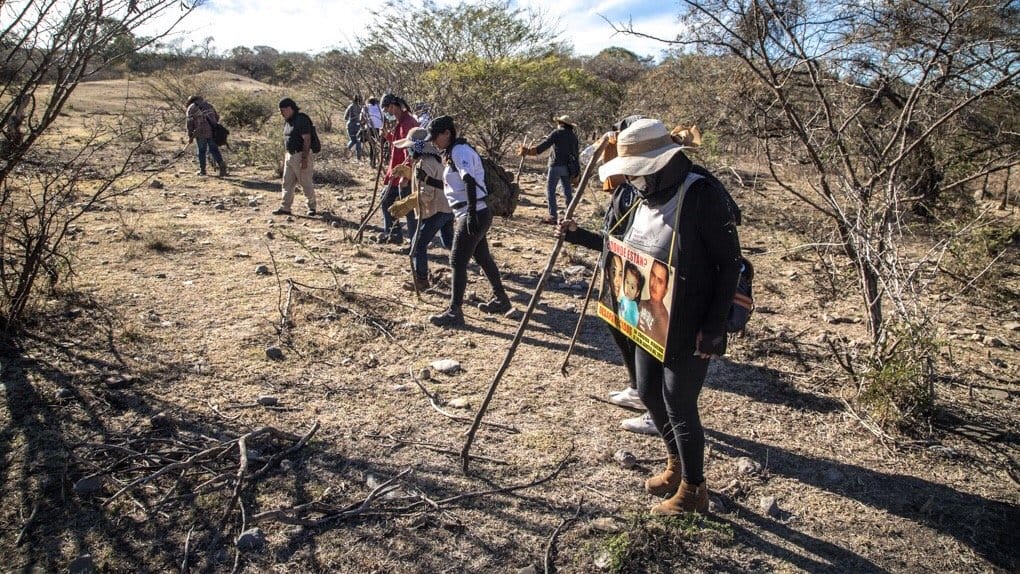 Grupo de personas en búsqueda de desaparecidos en Sonora y Sinaloa. La señora del lado derecho tiene un sombrero color blanco con crema, suéter y pantalón color negro.